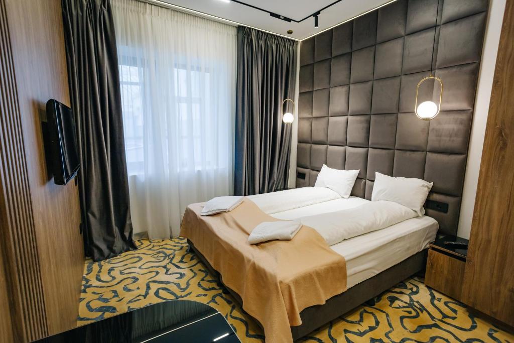 a bedroom with a large bed and a window at Hotel Dana 2 in Satu Mare