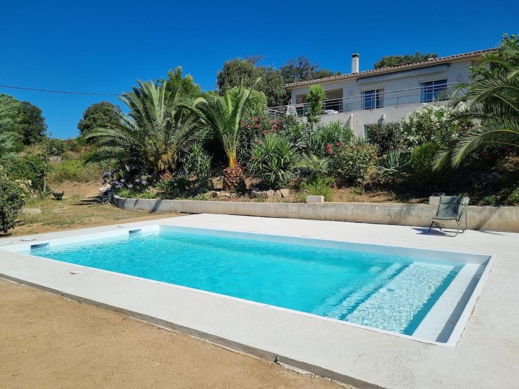 une piscine devant une maison dans l'établissement T2, rez de villa avec piscine, à Afa