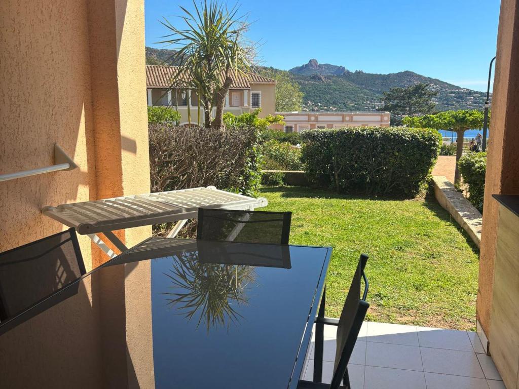 une table et des chaises sur le balcon d'une maison dans l'établissement 2 pièces RDJ climatisé avec accès piscine, tennis, golf et plus, proche Méditerranée et Massif de l'Estérel - FR-1-504-685, à Saint-Raphaël