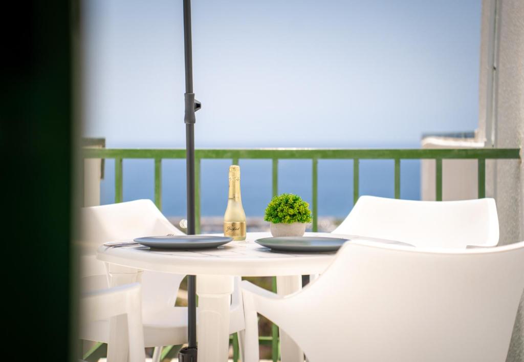 a table with two bottles of wine and two chairs at Apartamentos Halley in Puerto Rico de Gran Canaria