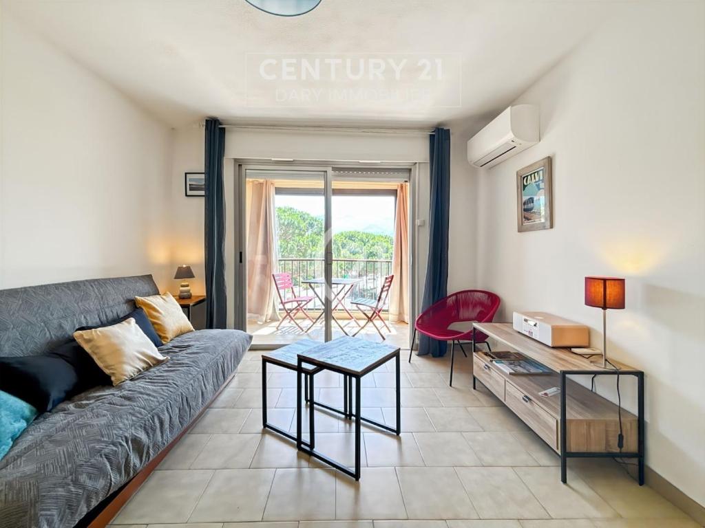 un salon avec un canapé et une table dans l'établissement La Roseraie Calvi, bord de mer, à Calvi