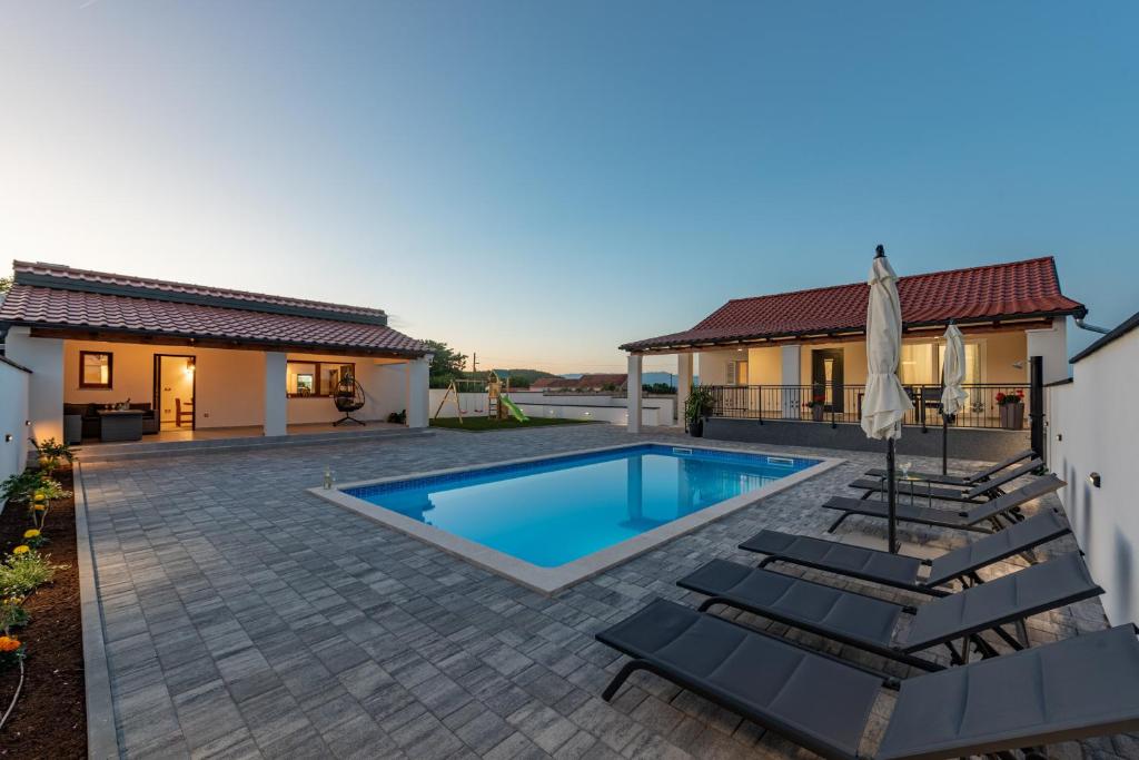 a swimming pool in the backyard of a house at Villa Chivas ZadarVillas in Donje Raštane