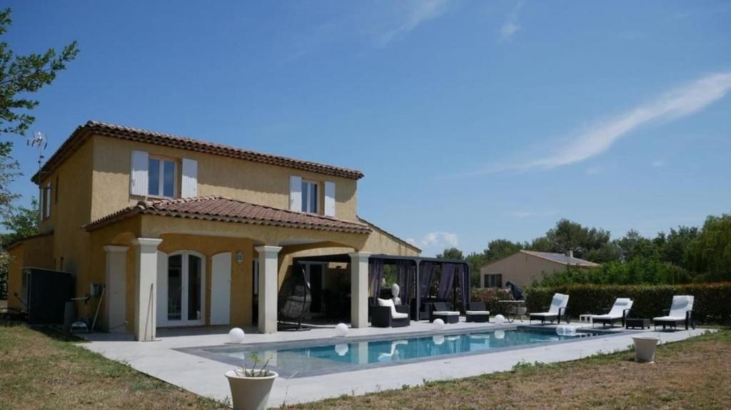 une maison avec une piscine devant dans l'établissement Villa calme avec piscine Luberon, à La Roque-dʼAnthéron