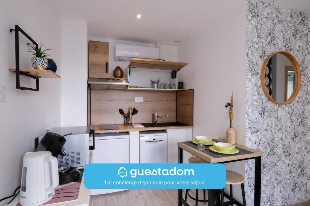 - une petite cuisine avec un comptoir et une table dans l'établissement Le Manoë- Proche GareSt Nazaire, à Saint-Nazaire