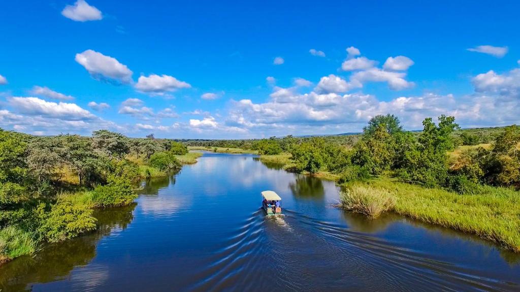 a small boat on a river in the middle at Royal Morubisi Founder's Lodge in Kaingo Private Game Reserve