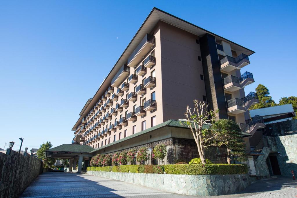 a building on a street next to a sidewalk at The Hedistar Hotel Narita in Narita