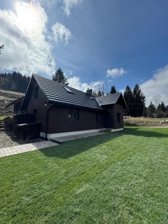 a house with a grass yard in front of it at Ostoja Zawoja in Zawoja