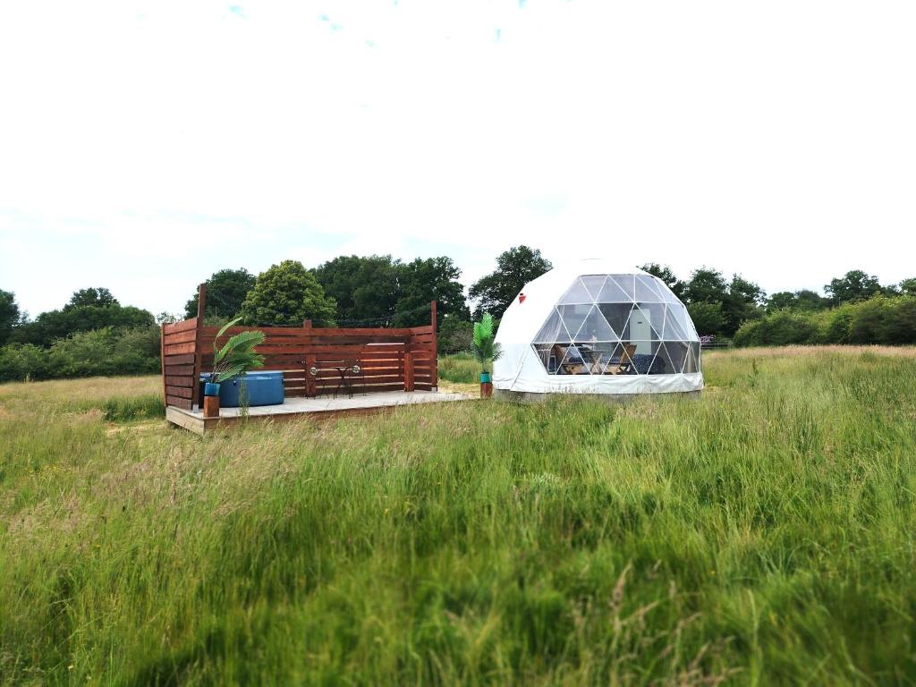 une serre et un banc dans un champ dans l'établissement Berry Dome, à Saint-Priest-la-Marche