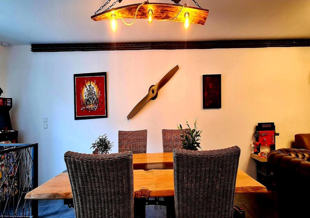 une salle à manger avec une table et une horloge au mur dans l'établissement Le 39 Dole Appartement industriel au cœur de Dole, à Dole