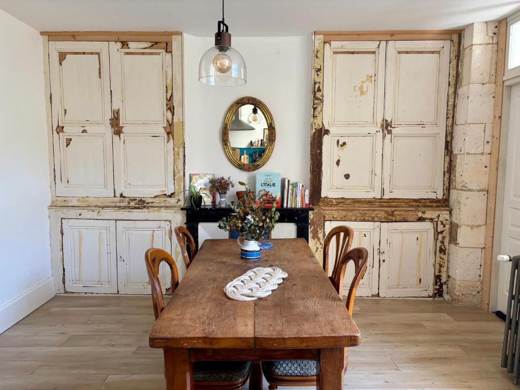 une salle à manger avec une table et des chaises en bois dans l'établissement Maison familiale en centre-ville, à Rochefort