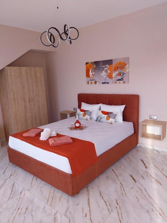 a bedroom with a large bed with red and white sheets at Villa Atspas studios in Skala Marion