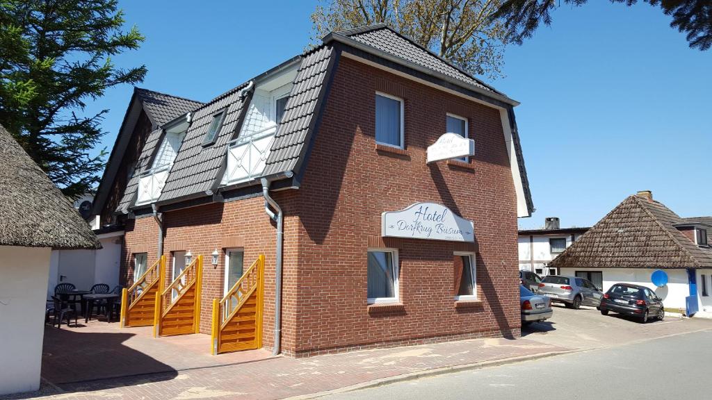 ein braunes Backsteingebäude mit einem Schild darauf in der Unterkunft Hotel Dorfkrug Büsum in Büsum