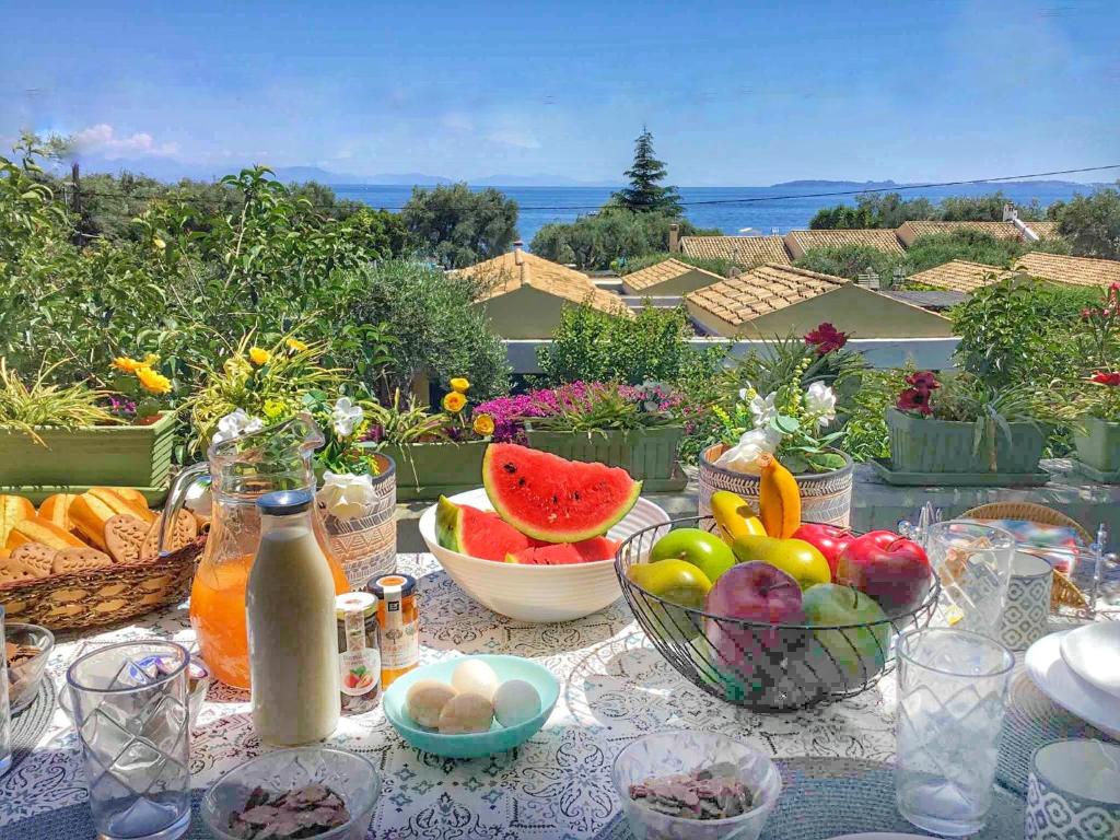 een tafel met fruit en groenten in kommen op een balkon bij Blue Marine 1 VIP Barbati On The Beach - Public Pool in Barbati