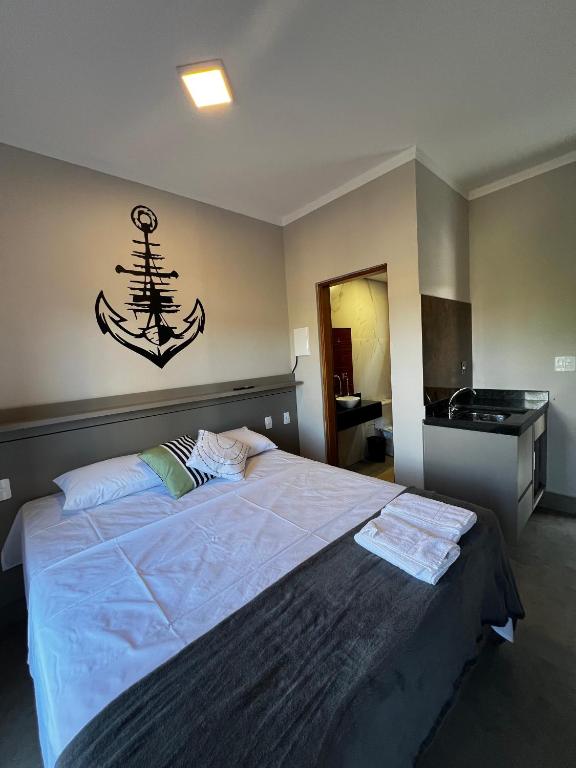 a bedroom with a large bed with a anchor on the wall at Pousada Casa Limão in Rifaina