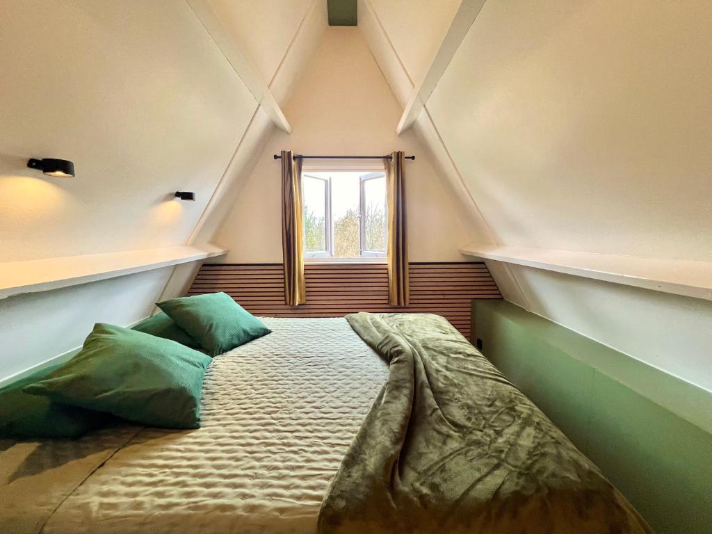 a bed in a room with a window at Bosgeluk Durbuy in Durbuy