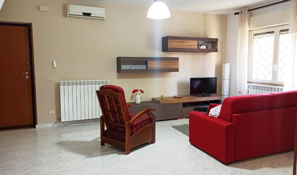 a living room with a red couch and a red chair at Appartamento Teresina in Atina