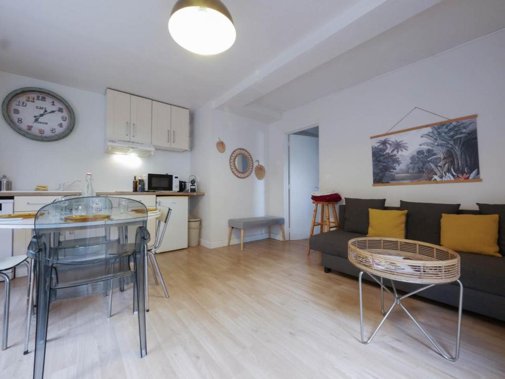 un salon avec un canapé et une horloge au mur dans l'établissement Le nid de la Canopée, à Montpellier