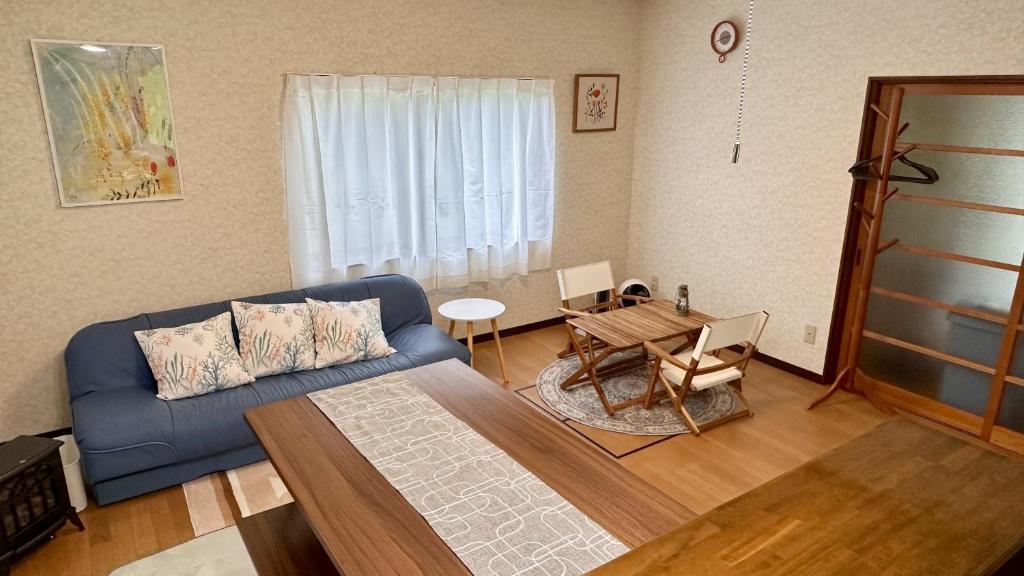 白山市にある白山麓の隠れ宿Takeoの青いソファとテーブルのあるリビングルーム