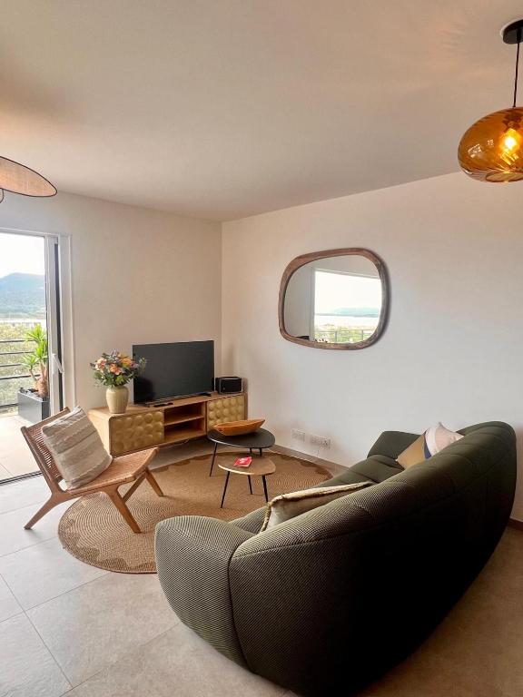 un salon avec un canapé et une télévision dans l'établissement Appartement CASA VISTA splendide vue sur le Golfe, à Porto-Vecchio