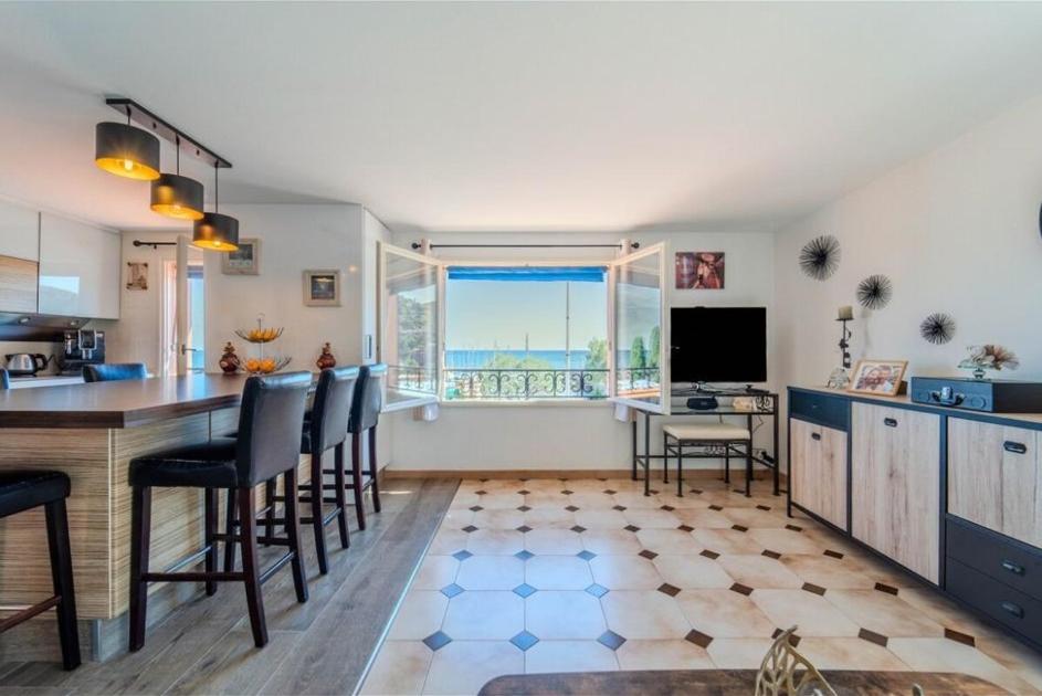 une cuisine avec une table et des chaises dans une pièce dans l'établissement Face à la mer, à Théoule-sur-Mer