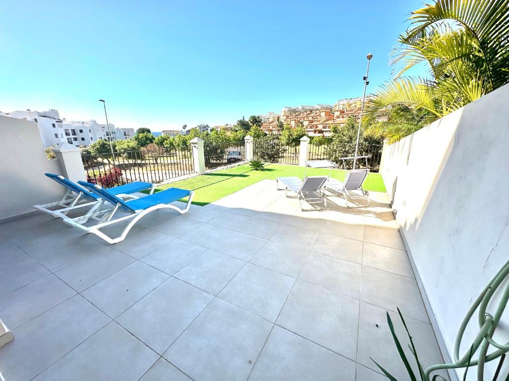 a patio with two chairs and a table on a balcony at La Cala de Mijas, groundfloor 2 bed apartment steps away from the beach in Mijas Costa