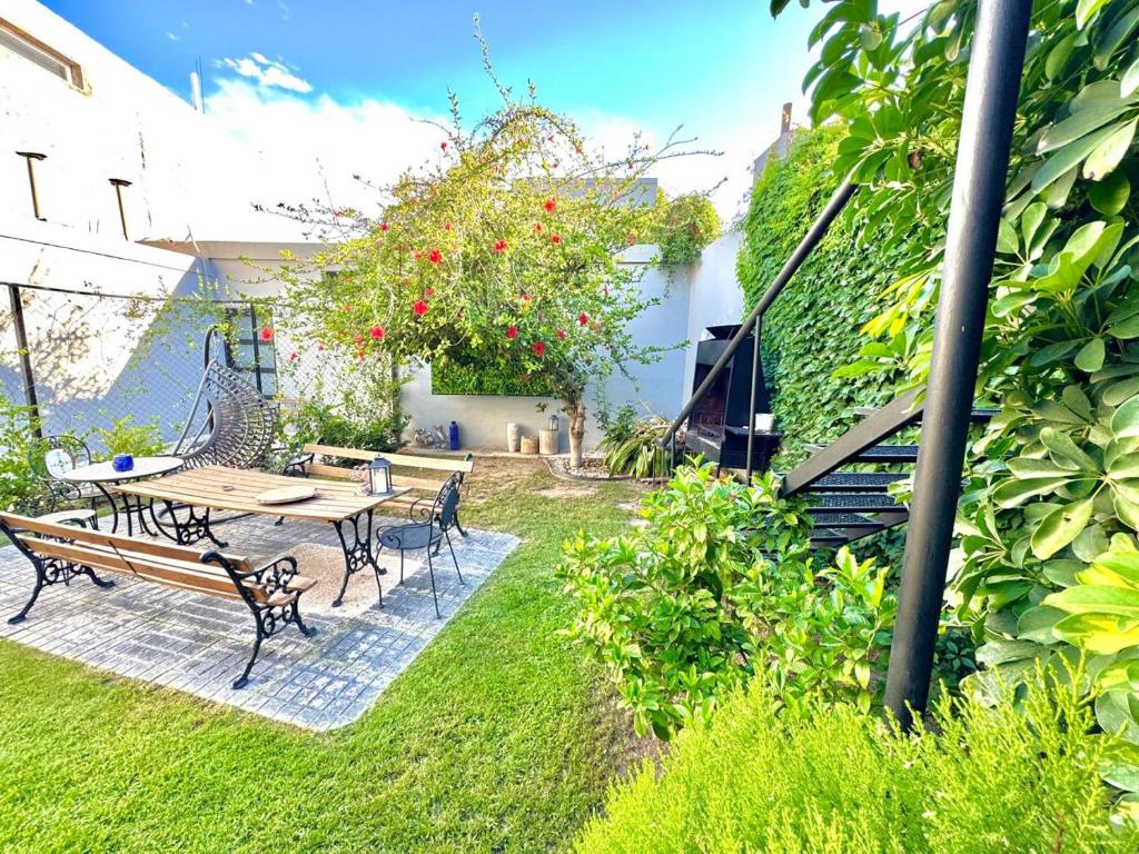 a patio with a table and chairs and a tree at Cómodo departamento 2 dormitorios con jardín sobre Avenida Libertador in San Juan