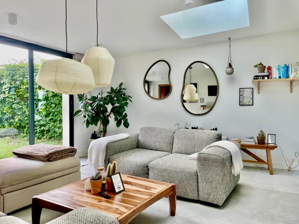 Saint-Côme-de-FresnéにあるLa Maison Rose - Côté Terre by Melroseのソファとテーブルのあるリビングルーム