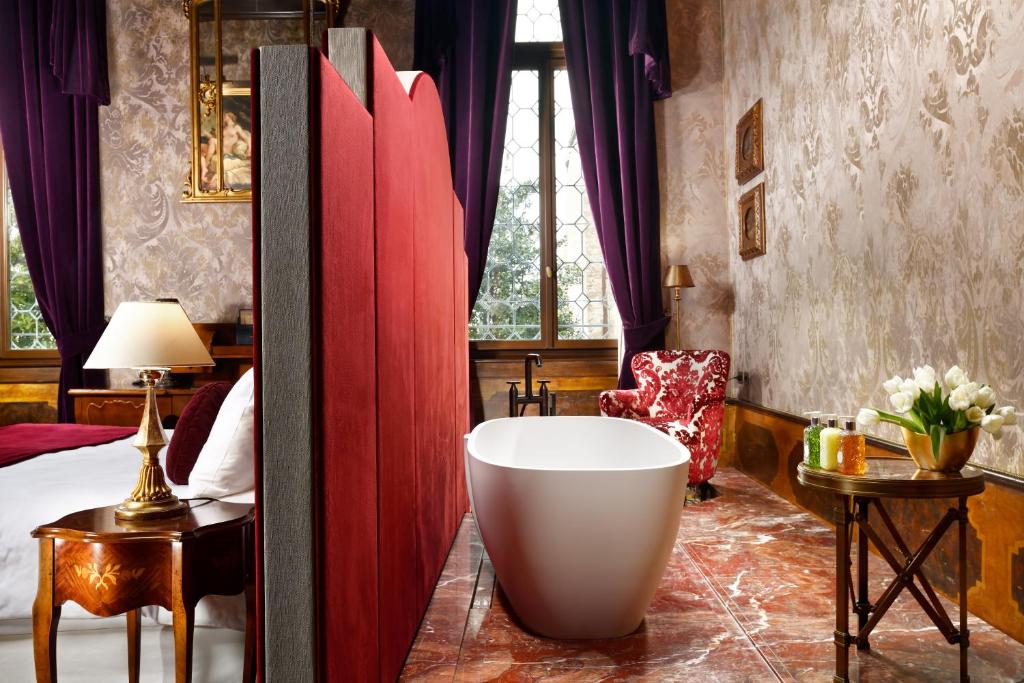 a bathroom with a bath tub in a bedroom at Palazzo Venart Luxury Hotel in Venice