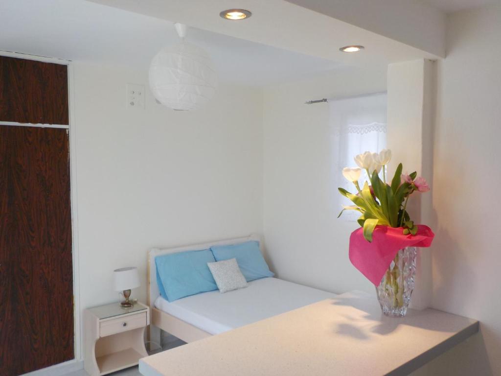 um quarto com um sofá e um vaso de flores sobre uma mesa em Mini City Center Studio in Ilha de Rhodes