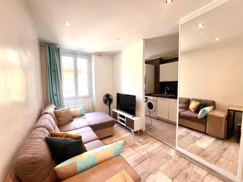 un salon avec un canapé et une télévision dans l'établissement Residence Lascaris, à Nice