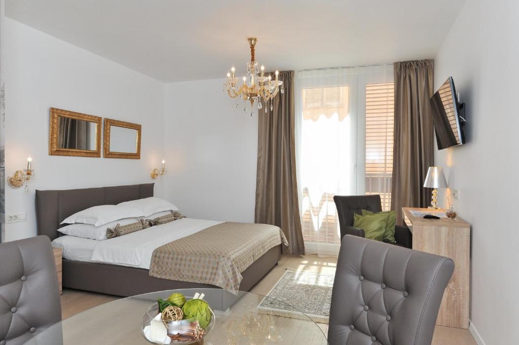 扎達爾的住宿－Luka Residence Apartments 1，卧室配有一张床和一张桌子及椅子