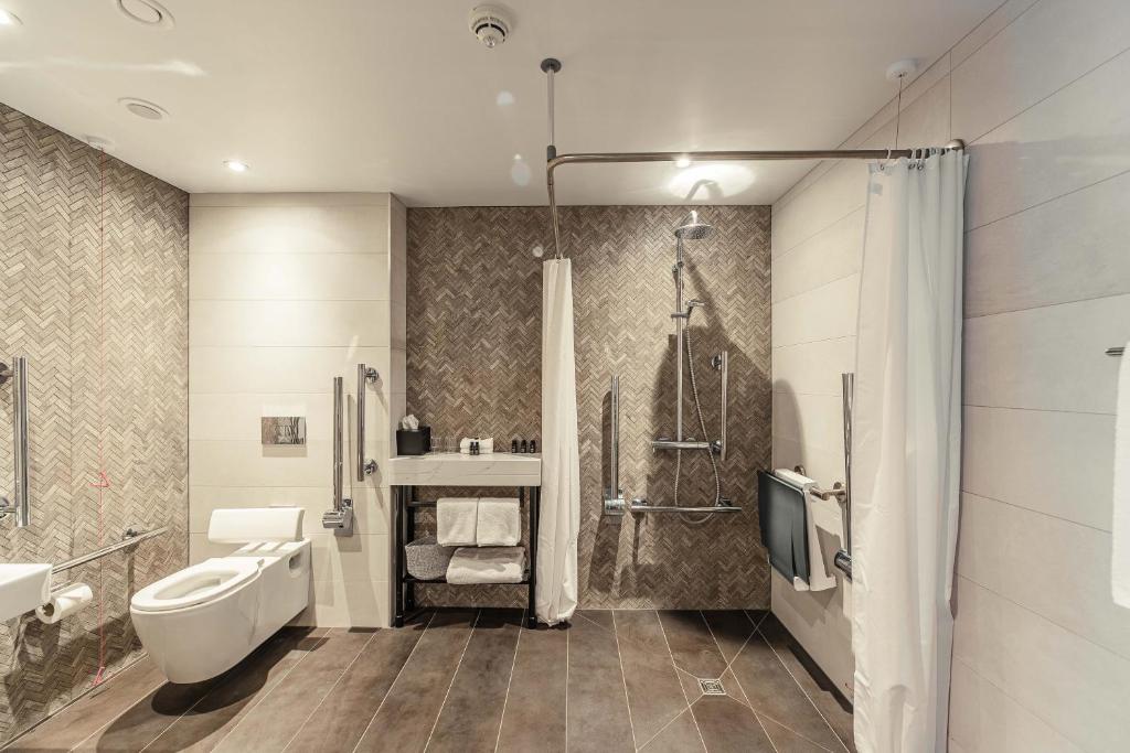 een badkamer met een wastafel en een douche bij The Fellows House Cambridge, Curio Collection By Hilton in Cambridge