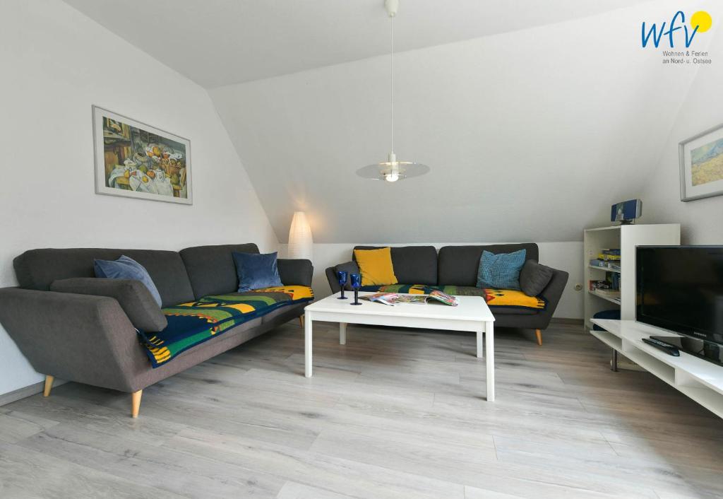 a living room with a couch and a table at Ferienhaus Caterlieschen Ferienwohnung 2 in Juist