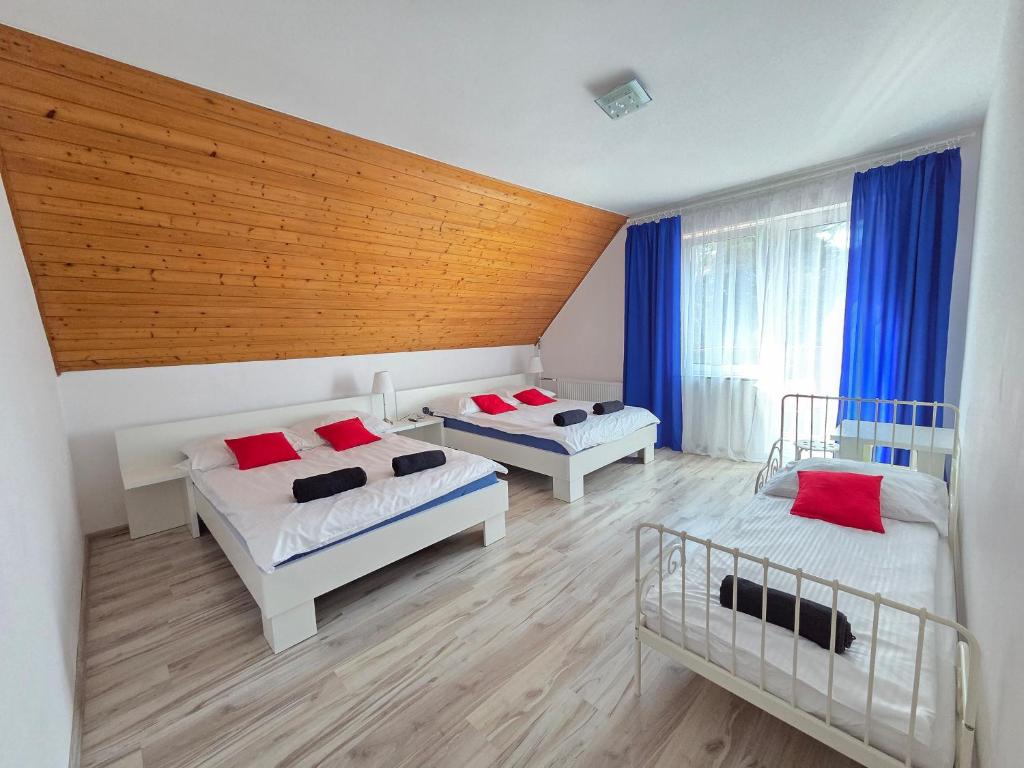 a bedroom with two beds and a wooden ceiling at Villa Azalia in Jastrzębia Góra