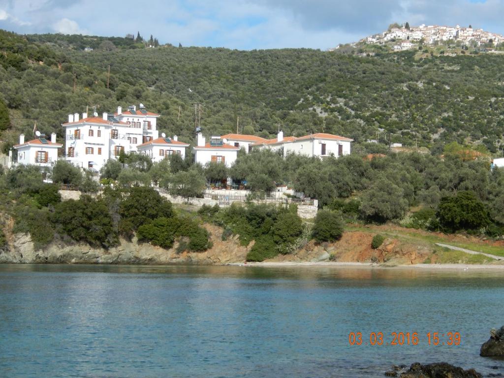a group of houses on a hill next to a river at Argo - Mythos in Tríkeri