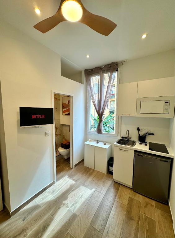 - une cuisine avec un ventilateur de plafond et un comptoir dans l'établissement Cosy studio le port, à Nice