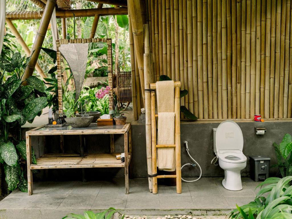 a bathroom with a toilet and a table with a ladder at Kumbuh Jungle in Susut
