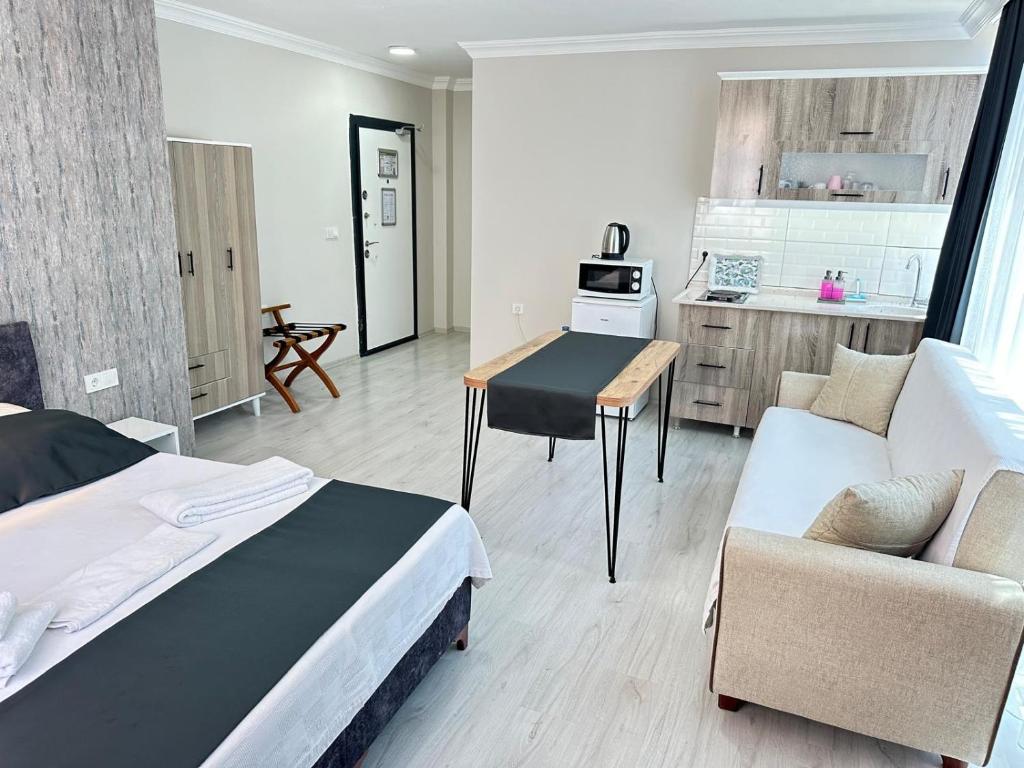 a bedroom with a bed and a table and a kitchen at Upart Flats by REFE in Antalya