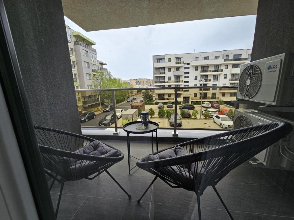 Dos sillas y una mesa en un balcón con vista. en Cosy Place Milano, en Constanţa