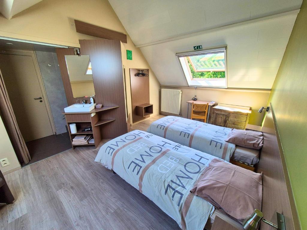 una camera d'albergo con due letti e un lavandino di B&B Tlekkerbeddeke a Rumst