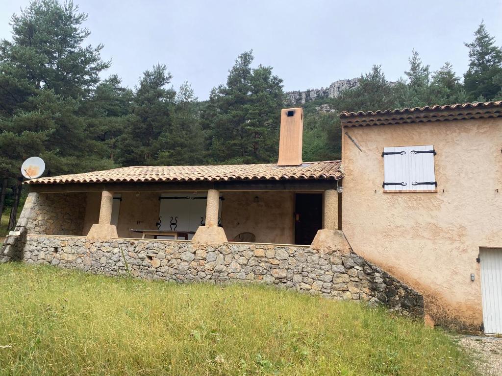 une maison avec un mur en pierre devant elle dans l'établissement Les bichons, à Valderoure