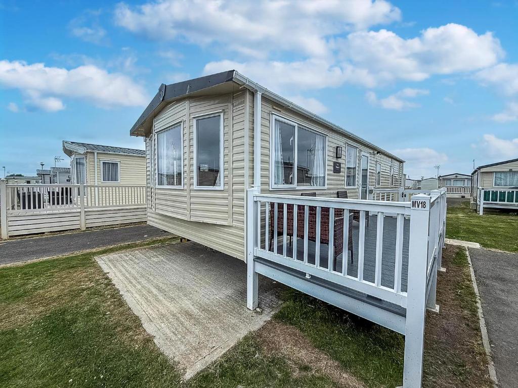 a house with a white porch and a fence at Great 6 Berth Caravan In Essex At St Osyth Beach Holiday Park Ref 28018Mv in Clacton-on-Sea