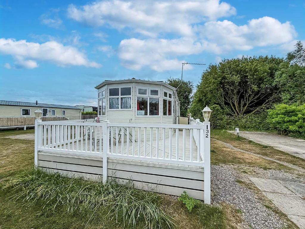 una casa bianca dietro una recinzione bianca di Great Dog Friendly Caravan To Hire With Field Views In Norfolk Ref 10132B a Belton