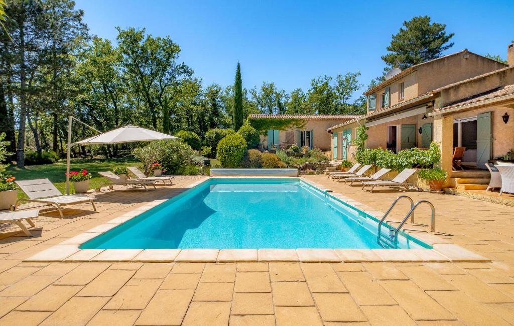 a swimming pool in a yard with chairs and a house at Gorgeous Home In Callian With Wifi in Callian
