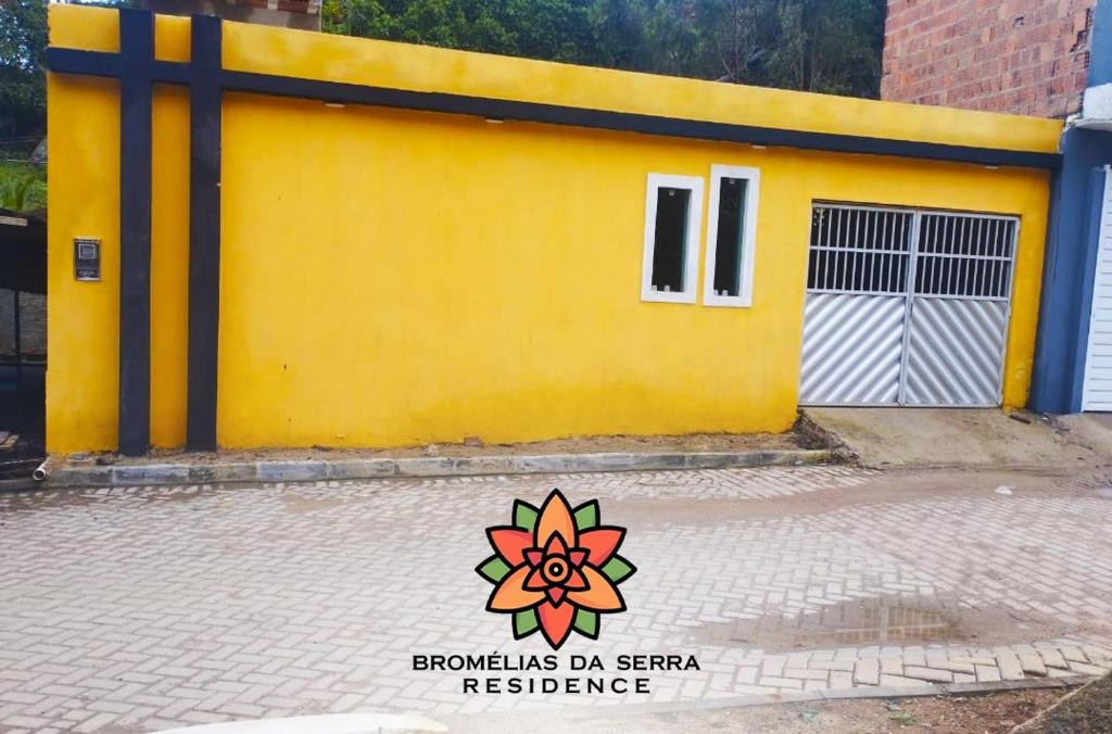 a yellow building with a flower painted on it at Bromélias da Serra Residence in Bezerros