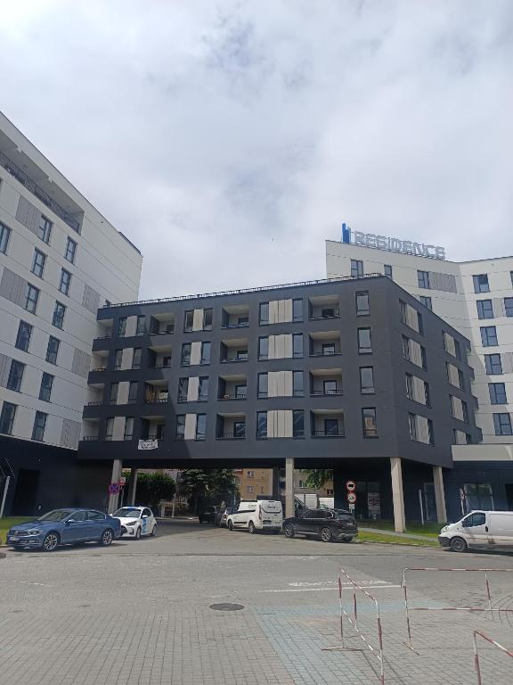 a large building with cars parked in a parking lot at Apartament Exclusive in Rzeszów