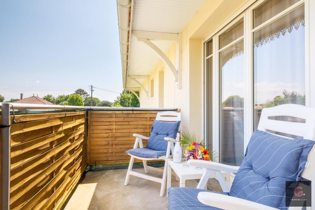 - une terrasse couverte avec 2 chaises et une fenêtre dans l'établissement T2 confort à Biscarrosse, 4 personnes, parking privé, classé 1 étoile, à Biscarrosse