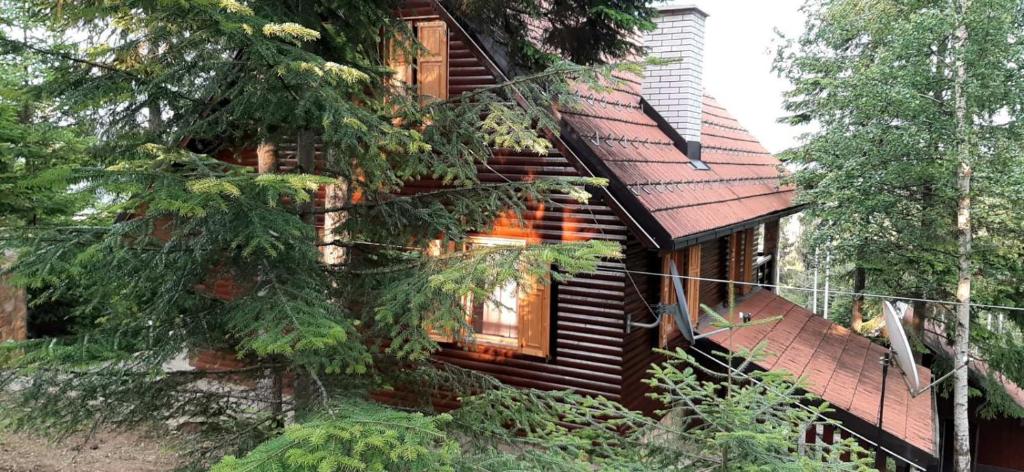 una baita di tronchi con un albero di fronte di Tri Srca a Nova Varoš