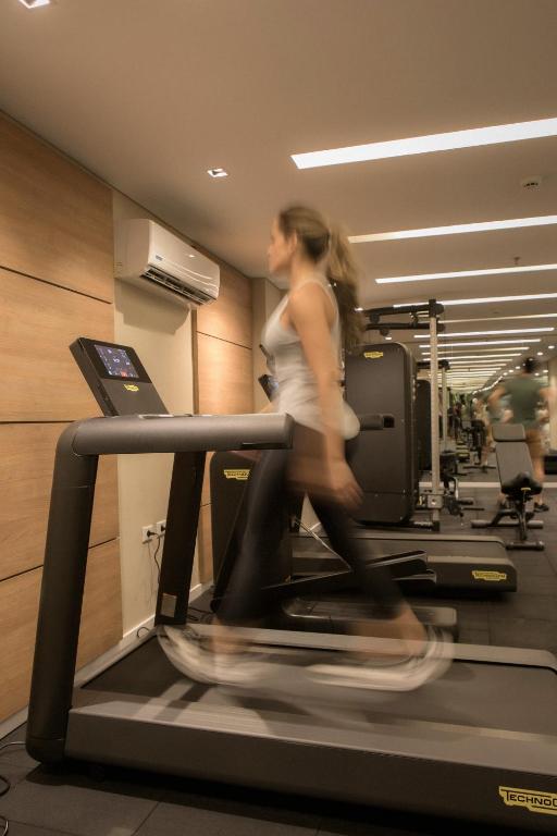 a woman running on a treadmill in a gym at Hub Hotel Asuncion in Asuncion