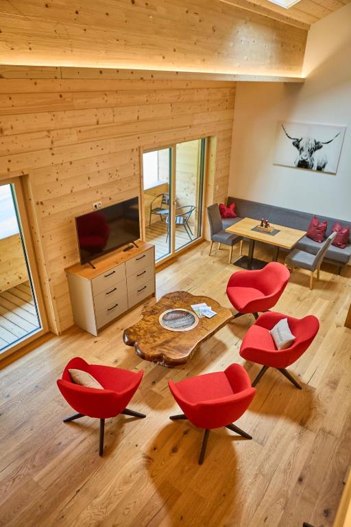 a living room with red chairs and a table at Bocks Apartments 53C in Wald am Arlberg